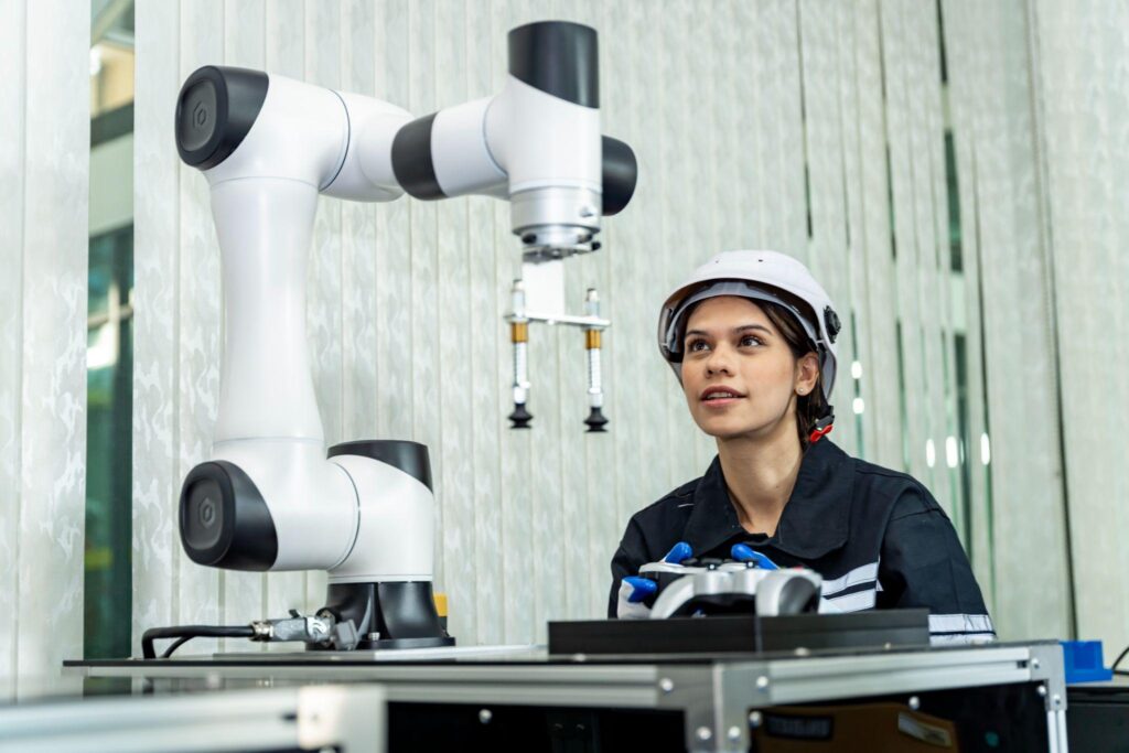 An engineer observes a robotic arm following troubleshooting fixes